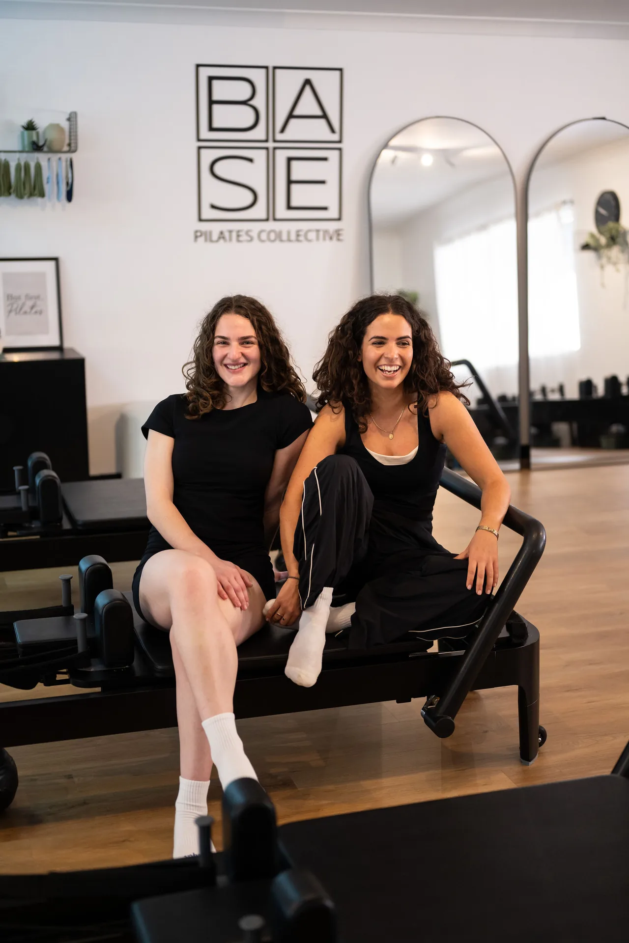 Two women smiling together in the BASE Pilates studio